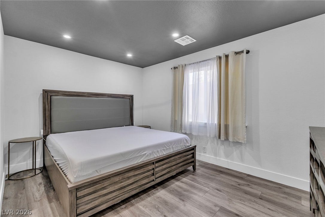4170 Sheppard Drive, Las Vegas, NV 89121 Recessed lighting and warm wood flooring enhance this modern bedroom.