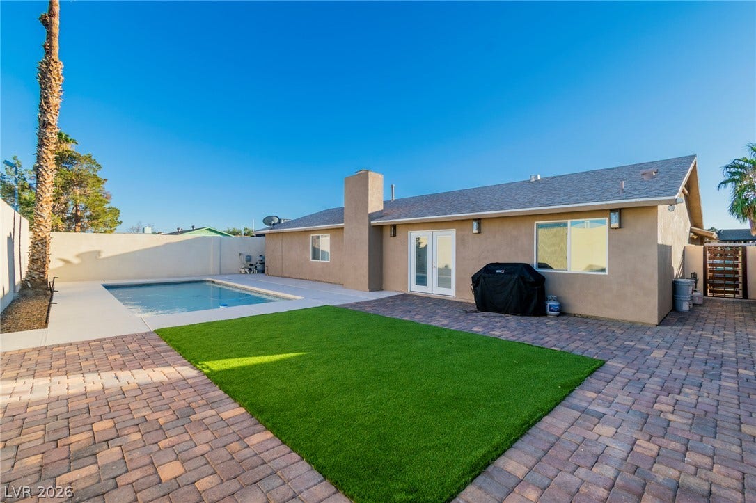 4170 Sheppard Drive, Las Vegas, NV 89121 An inviting backyard oasis features a sparkling swimming pool, manicured lawn, and brick paver patio.