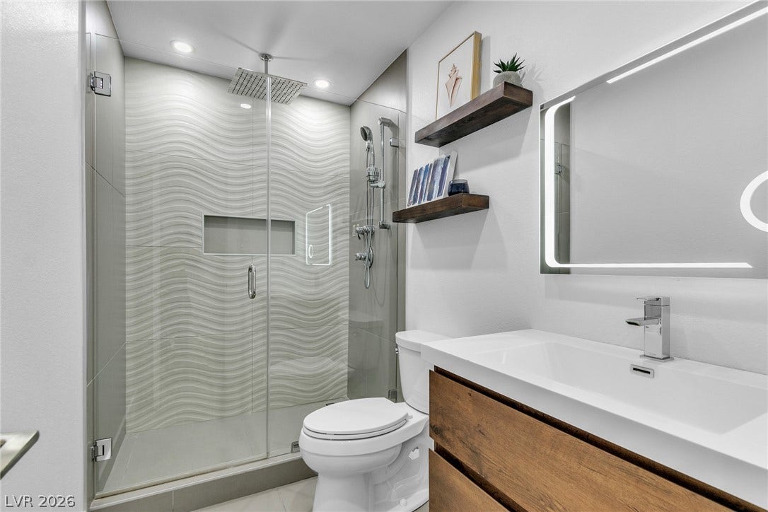 4170 Sheppard Drive, Las Vegas, NV 89121 Modern finishes define this bathroom, highlighted by a textured tile shower and floating shelves.