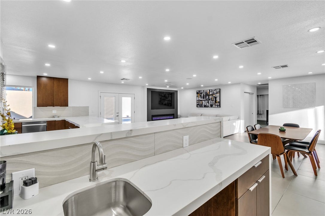 4170 Sheppard Drive, Las Vegas, NV 89121 Recessed lighting illuminates an open floorplan with stone counters and modern tiled flooring.
