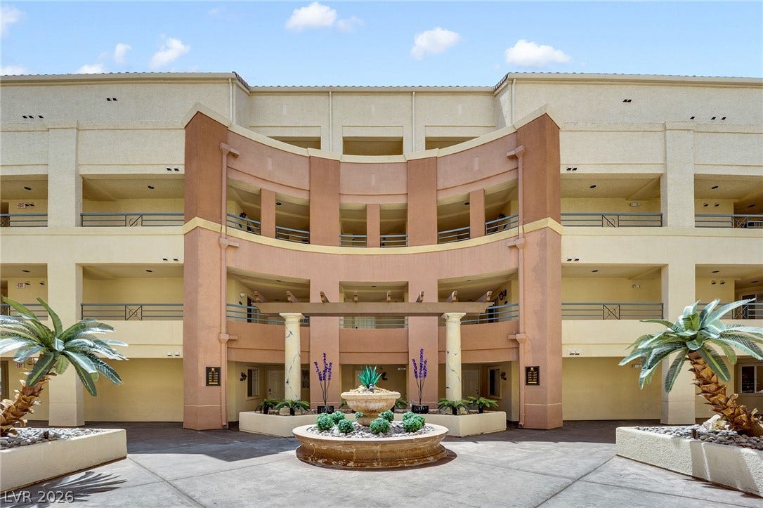 220 E Flamingo Road, #117, Las Vegas, NV 89169 An elegant stucco courtyard entry showcases curved architectural lines and a central stone water feature.