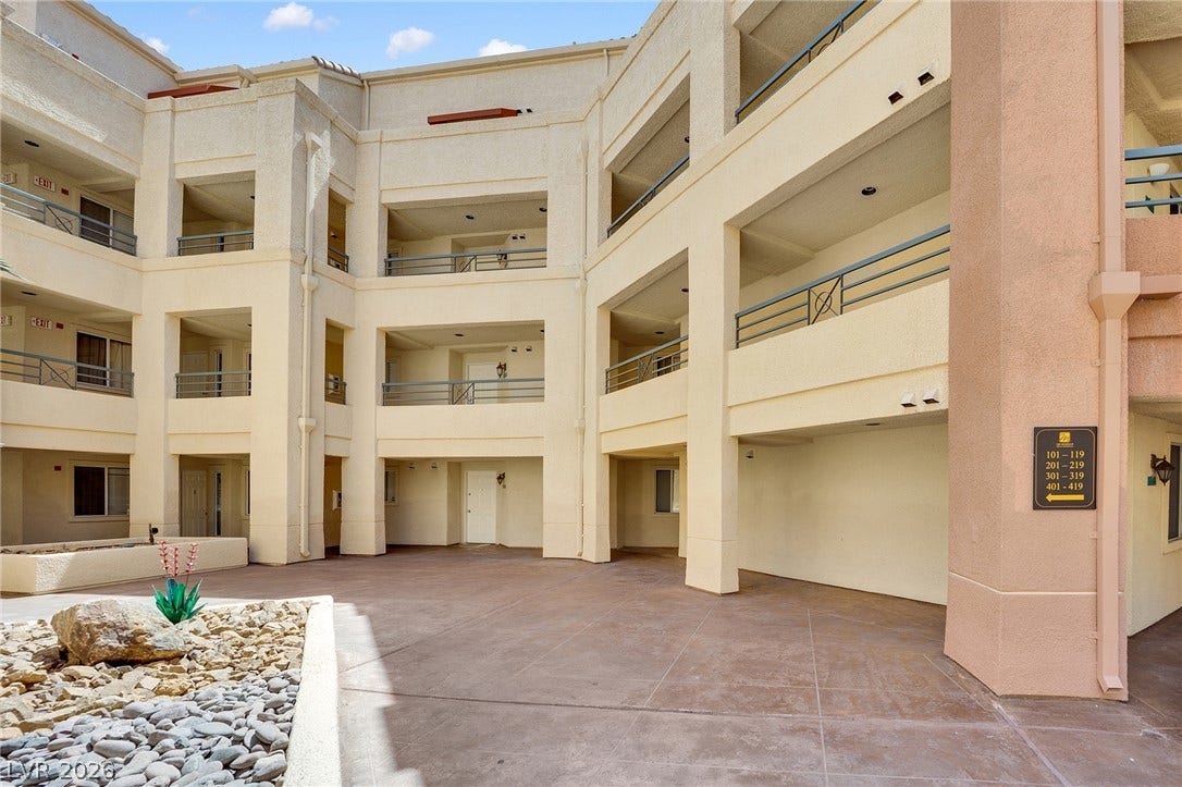 220 E Flamingo Road, #117, Las Vegas, NV 89169 Multi-level outdoor corridors overlook a spacious stucco courtyard under a blue sky.