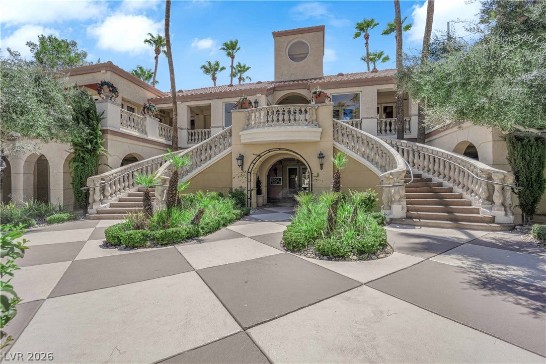 220 E Flamingo Road, #117, Las Vegas, NV 89169 Grand dual staircases frame the entryway of this Mediterranean-style villa with checkered stone paving.