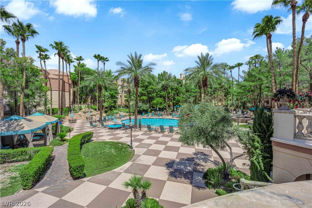 220 E Flamingo Road, #117, Las Vegas, NV 89169 Lush palm trees and patterned stone tiling surround a resort-style swimming pool area.