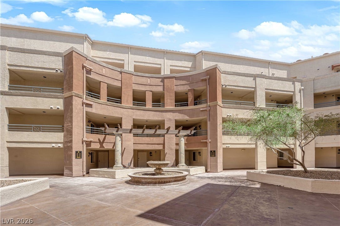220 E Flamingo Road, #117, Las Vegas, NV 89169 Multi-level stucco exterior surrounds a central paved courtyard featuring a tiered stone fountain.
