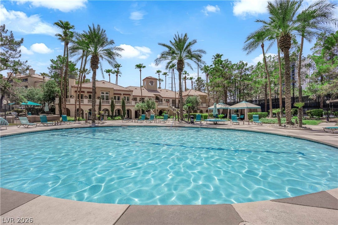 220 E Flamingo Road, #117, Las Vegas, NV 89169 Palm trees surround a large community swimming pool situated in front of the stucco clubhouse.