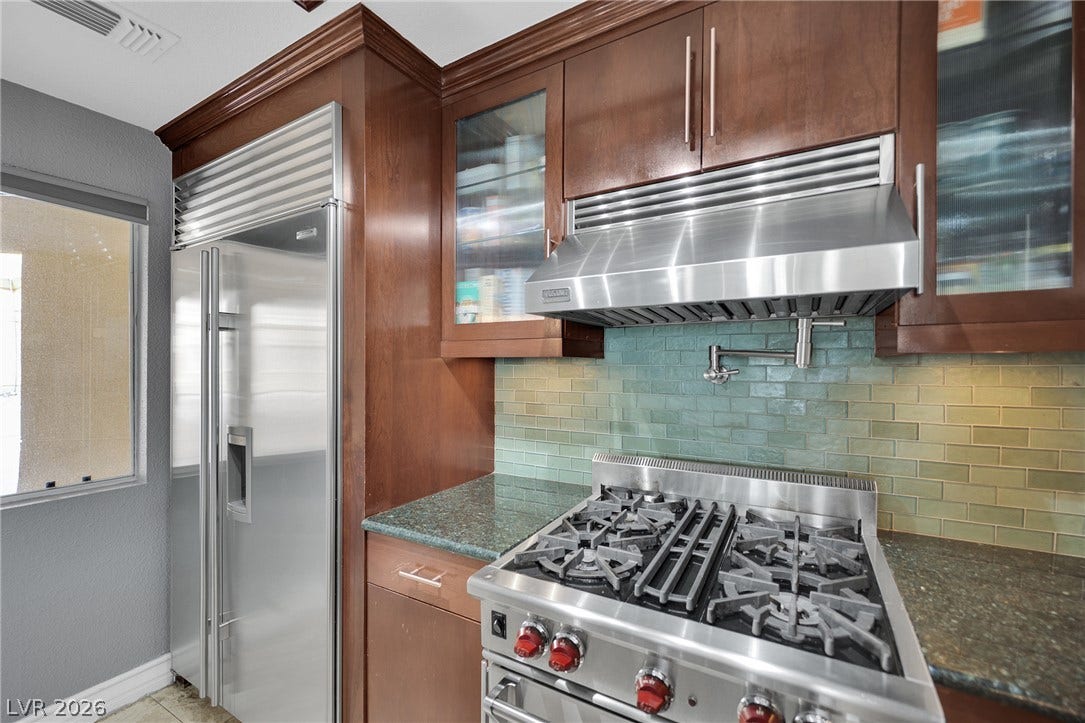 220 E Flamingo Road, #117, Las Vegas, NV 89169 Rich wood cabinetry surrounds high-end stainless steel appliances and a vibrant tiled backsplash.