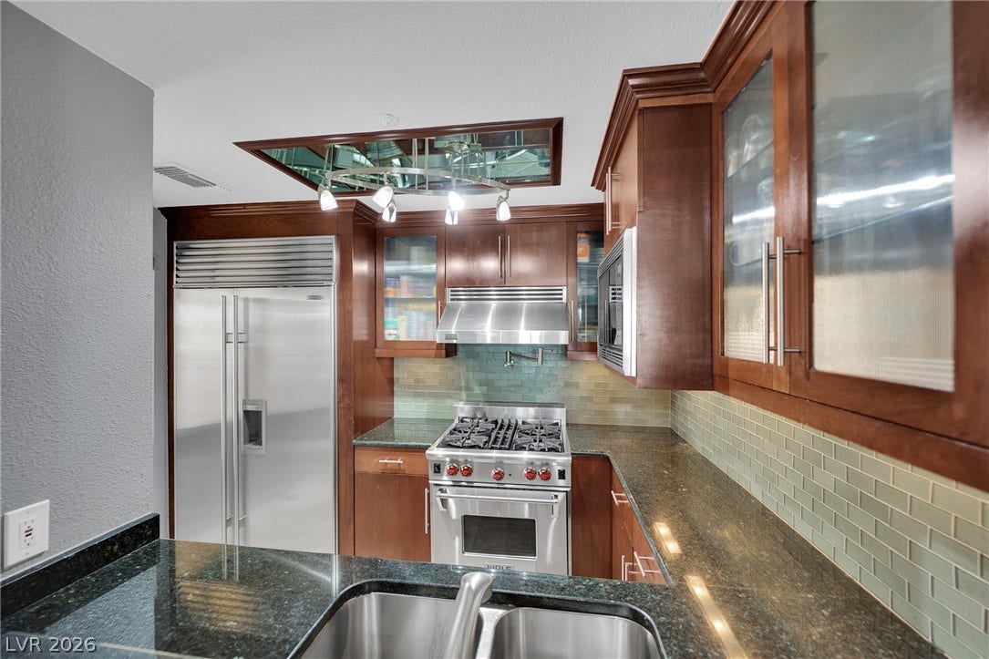 220 E Flamingo Road, #117, Las Vegas, NV 89169 Rich wood cabinetry paired with dark granite countertops defines this well-equipped culinary space.