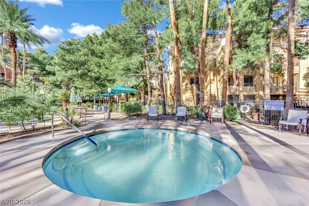 220 E Flamingo Road, #117, Las Vegas, NV 89169 Mature trees shade a circular in-ground spa surrounded by a concrete patio.