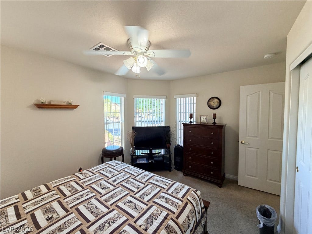 3917 Robin Knot Court, North Las Vegas, NV 89084 Natural light streams through multiple windows in this cozy front bedroom featuring soft carpeting.