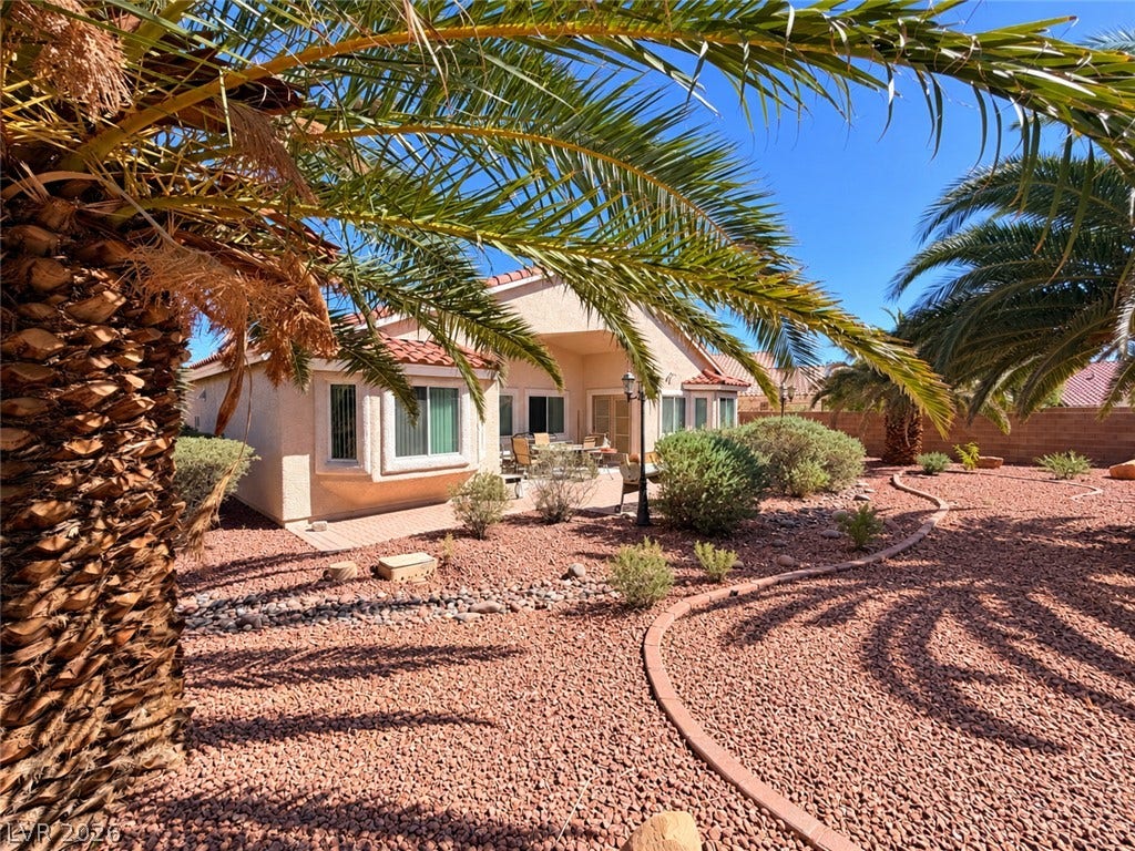 3917 Robin Knot Court, North Las Vegas, NV 89084 Mature palms frame a low-maintenance desert landscape surrounding the tiled-roof stucco home.