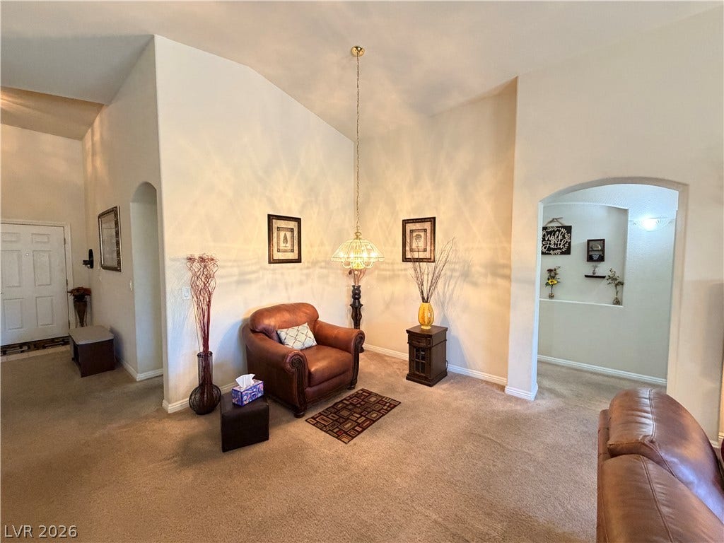 3917 Robin Knot Court, North Las Vegas, NV 89084 Vaulted ceilings and soft carpeting define this inviting living area featuring wide arched entryways.
