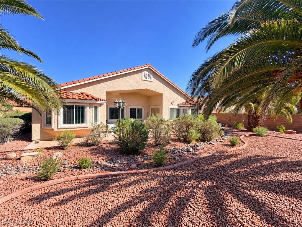 3917 Robin Knot Court, North Las Vegas, NV 89084 Palm trees and low-maintenance desert landscaping frame the classic tile-roof exterior of this home.