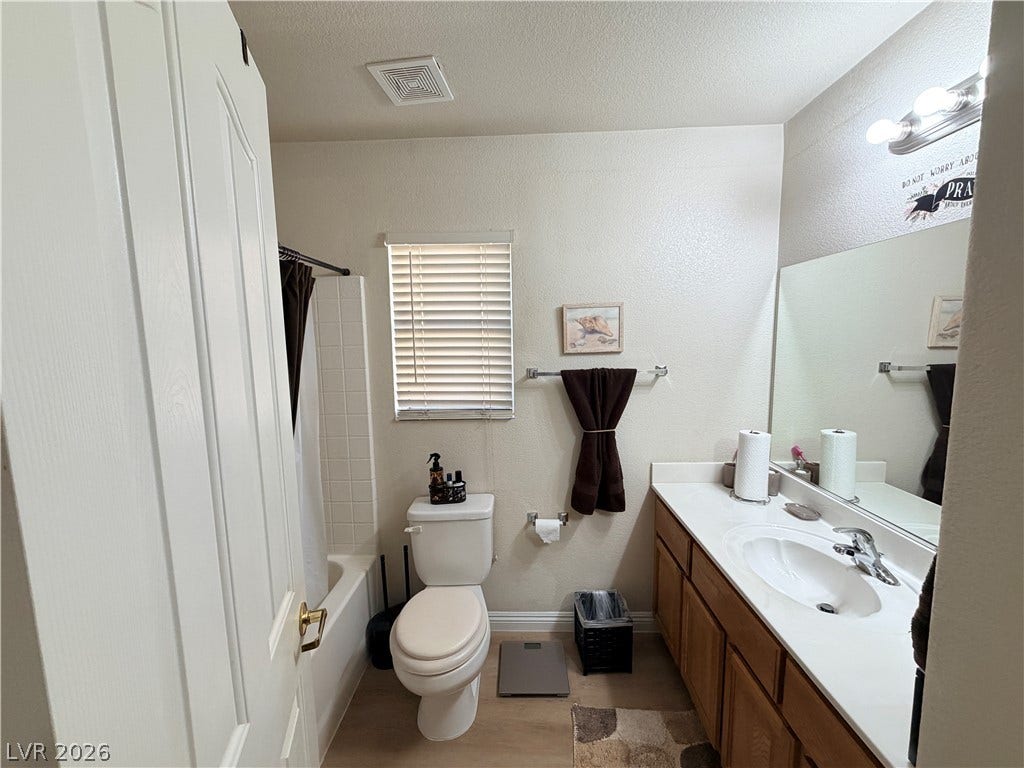 3917 Robin Knot Court, North Las Vegas, NV 89084 A classic bathroom featuring a wood vanity and structured tub shower layout.