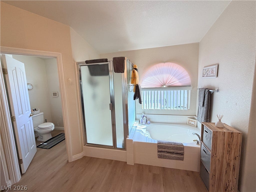 3917 Robin Knot Court, North Las Vegas, NV 89084 An arched window filters natural light over a built-in soaking tub and separate shower.