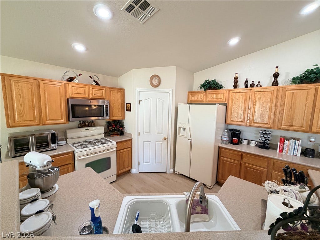 3917 Robin Knot Court, North Las Vegas, NV 89084 Ample wooden cabinetry and solid countertops define this highly functional kitchen layout.