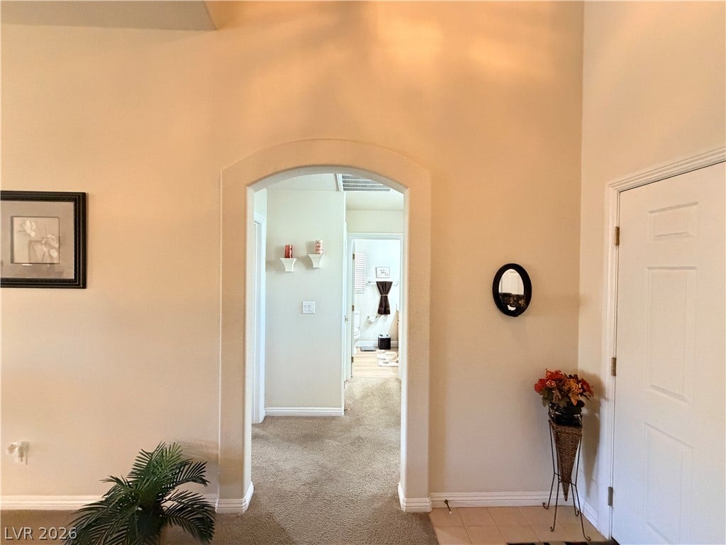 3917 Robin Knot Court, North Las Vegas, NV 89084 An arched doorway leads to the front bedroom and bathroom hallway under high ceilings.