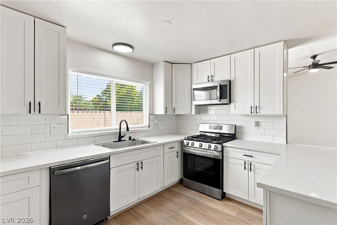 Gleaming stone countertops and classic subway tile backsplash accent this refreshed cooking space.