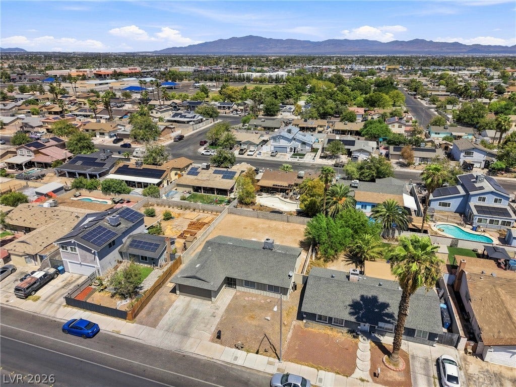A spacious neighborhood plot set against a scenic backdrop of distant mountains.