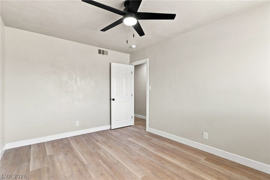 Smooth wood-look flooring and crisp baseboards anchor this versatile bedroom space.