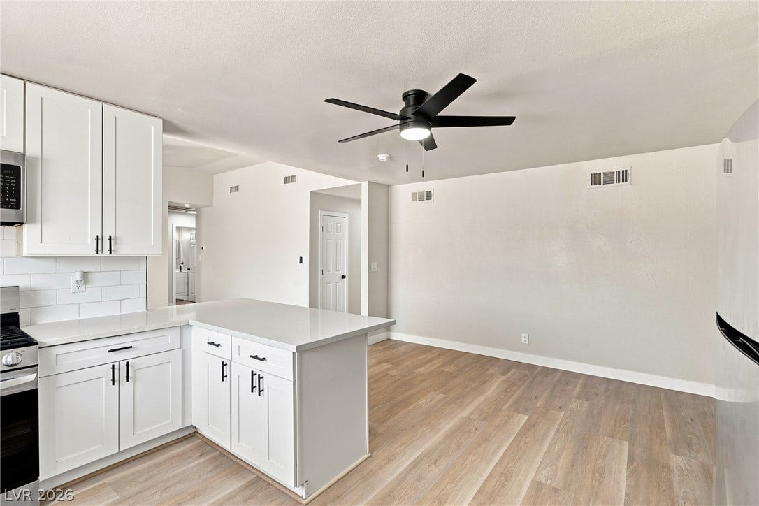 Clean lines and smooth flooring define this light-filled kitchen and adjoining living area.