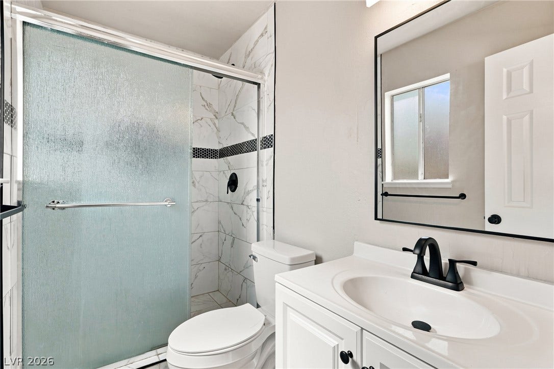 Crisp finishes and textured glass shower doors define this refreshed washroom space.