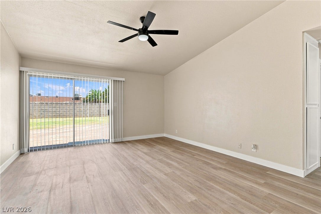 Sliding glass doors open directly to the backyard from this versatile living area.