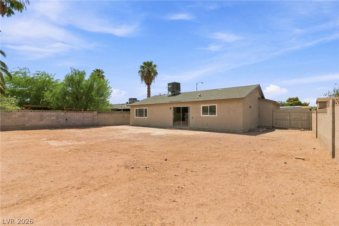 An expansive dirt backyard enclosed by block walls provides a blank canvas for landscaping.