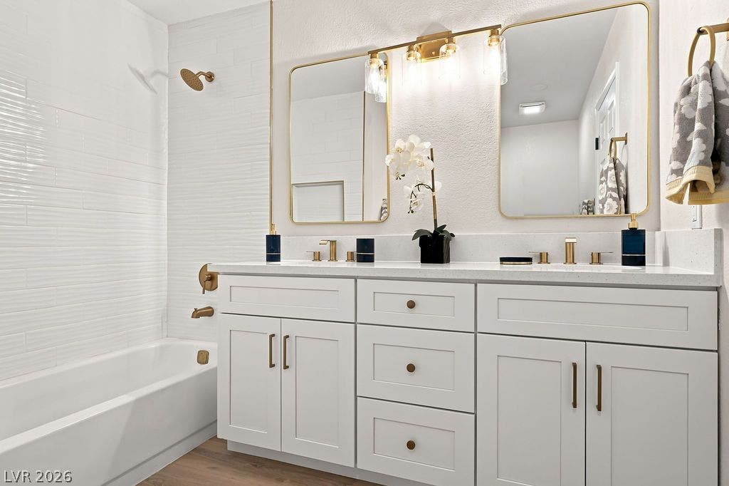 6250 W Flamingo Road, #62, Las Vegas, NV 89103 Newly updated en-suite bath featuring elegant gold hardware, a modern double vanity, and a pristine tiled tub and shower.
