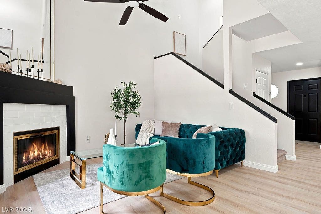 6250 W Flamingo Road, #62, Las Vegas, NV 89103 A beautifully styled living space highlighting a bold black-and-white fireplace, high ceilings, and stunning black staircase accents.