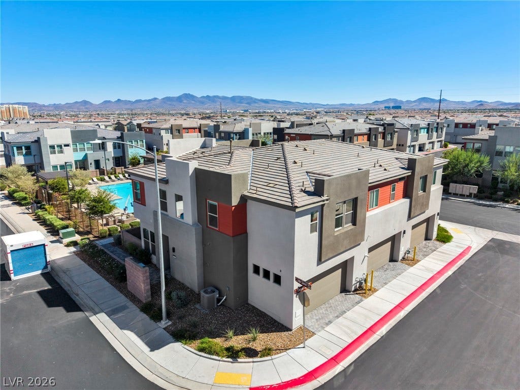 9826 Canyon Sage Street, Las Vegas, NV 89141 Modern multi-level exterior architecture stands set against a backdrop of distant desert mountains.
