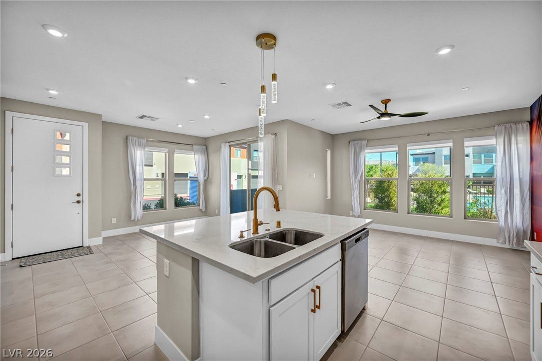 9826 Canyon Sage Street, Las Vegas, NV 89141 An open floorplan connects the modern kitchen island to the tiled dining space.