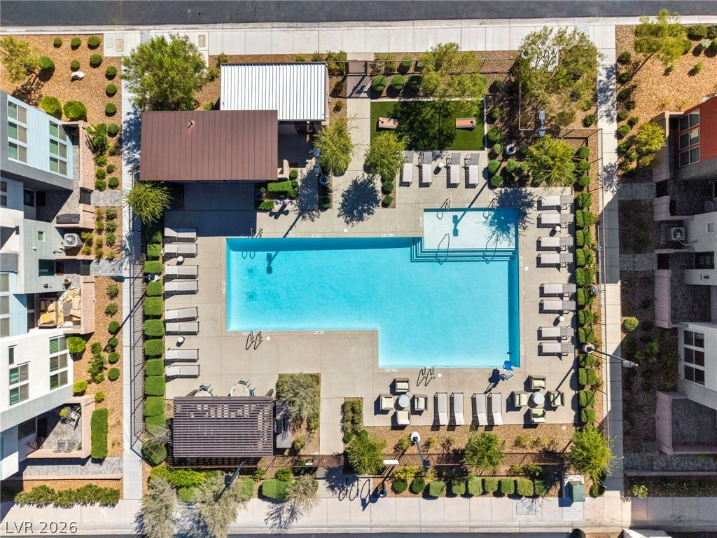 9826 Canyon Sage Street, Las Vegas, NV 89141 An aerial perspective showcases the pristine community swimming pool surrounded by manicured landscaping and lounging areas.