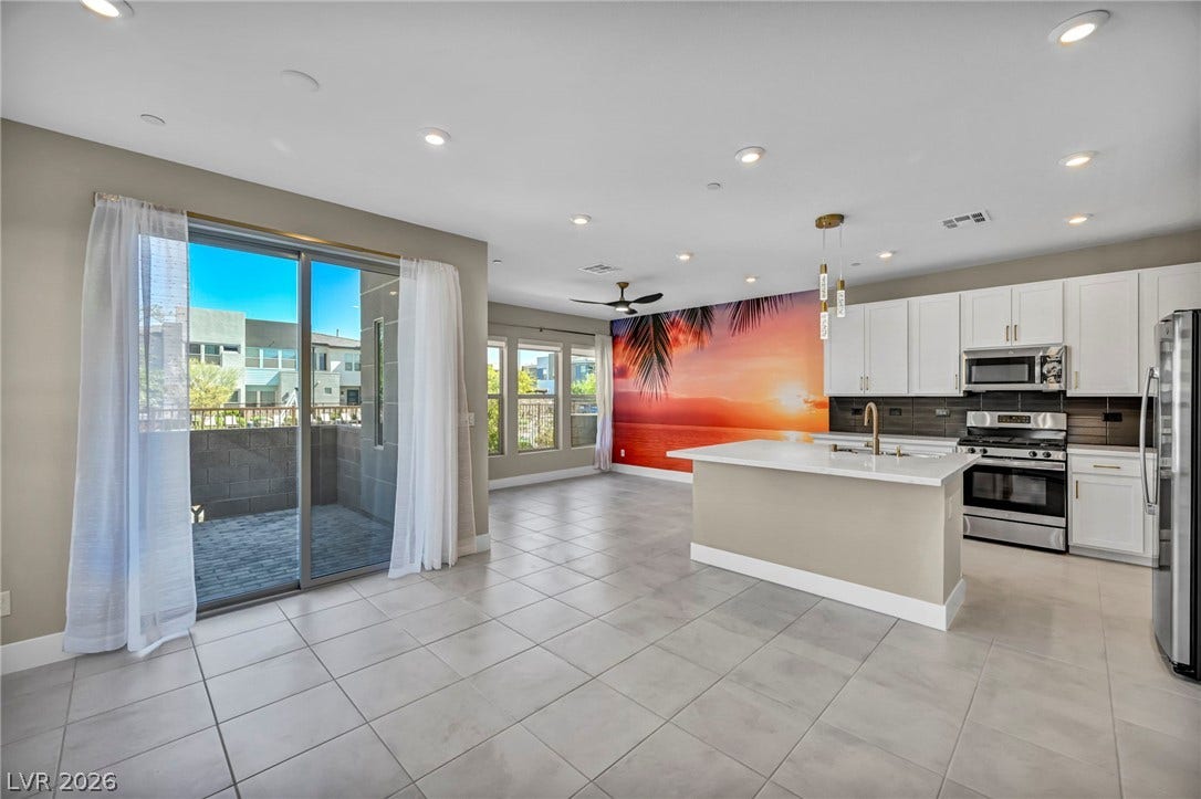 9826 Canyon Sage Street, Las Vegas, NV 89141 Sliding glass doors open to a private balcony from this modern open-concept space.