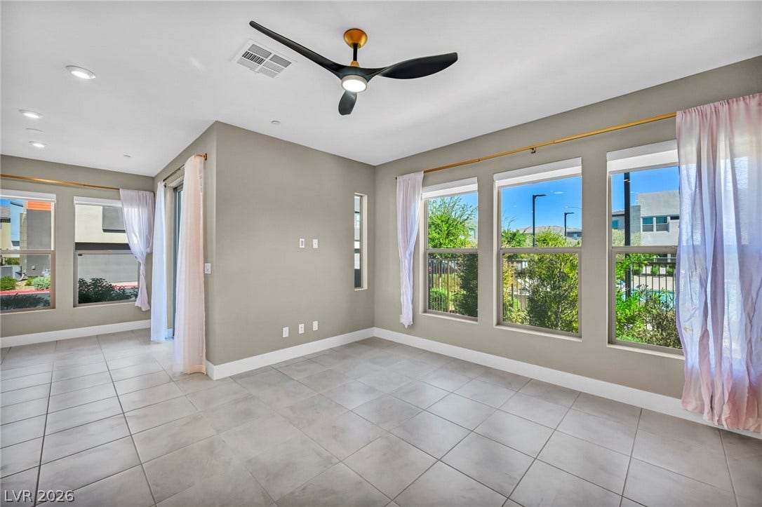9826 Canyon Sage Street, Las Vegas, NV 89141 Sunlight streams across tile flooring through expansive windows in this open-concept living space.
