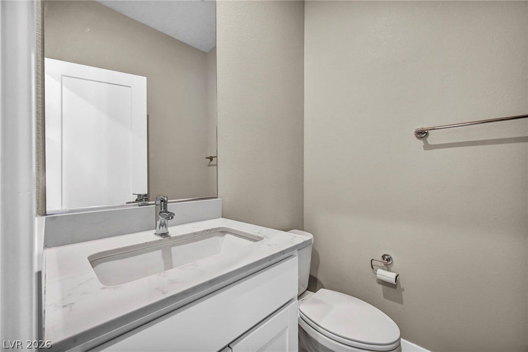 9826 Canyon Sage Street, Las Vegas, NV 89141 Clean lines and stone counters define this modern powder room.