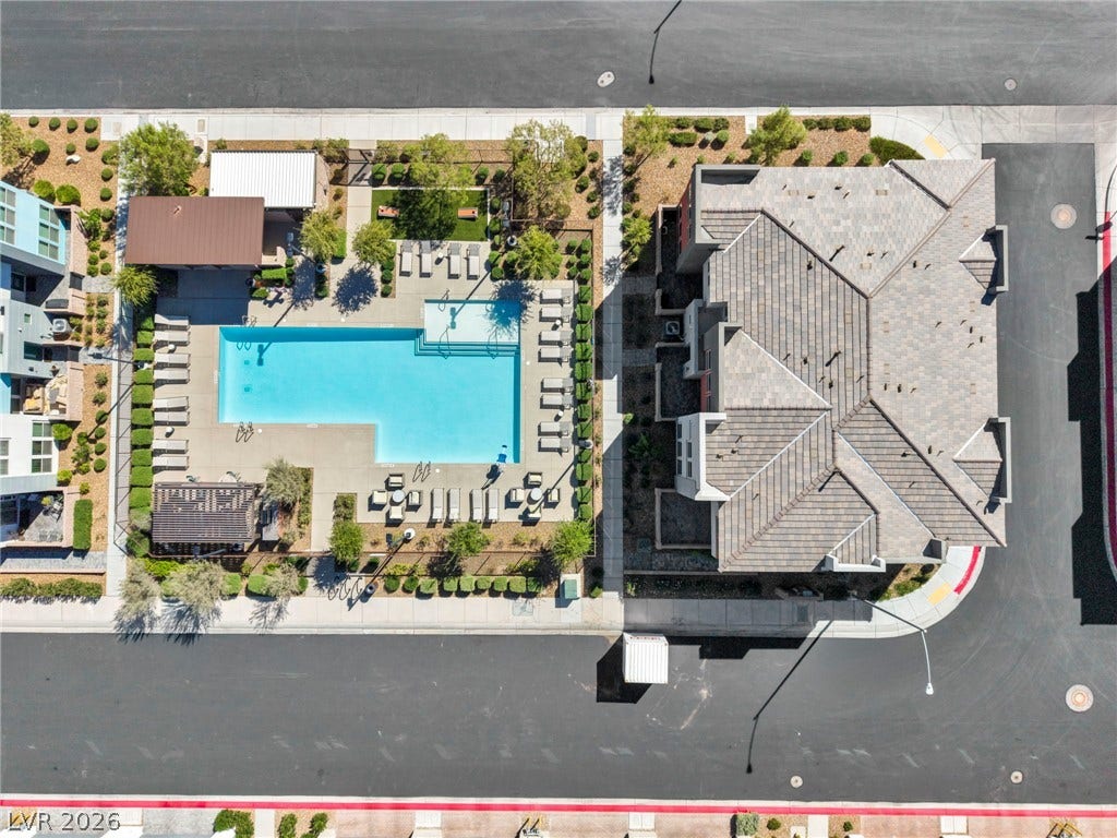 9826 Canyon Sage Street, Las Vegas, NV 89141 A sparkling community swimming pool rests adjacent to a modern multi-story residential building.