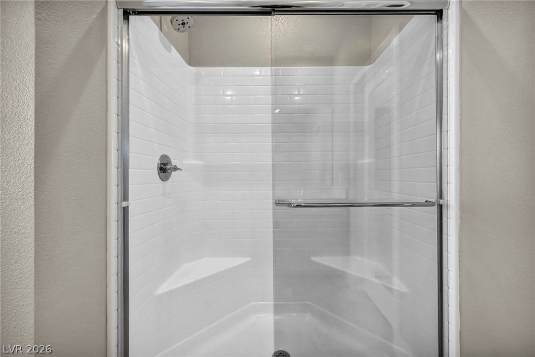 9826 Canyon Sage Street, Las Vegas, NV 89141 Crisp subway tile surrounds this modern walk-in shower featuring a built-in corner bench.