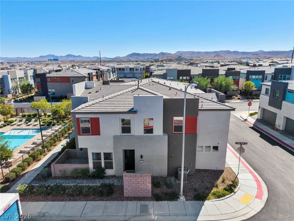 9826 Canyon Sage Street, Las Vegas, NV 89141 Modern multi-level exterior architecture under a clear blue sky overlooks distant mountain ranges.