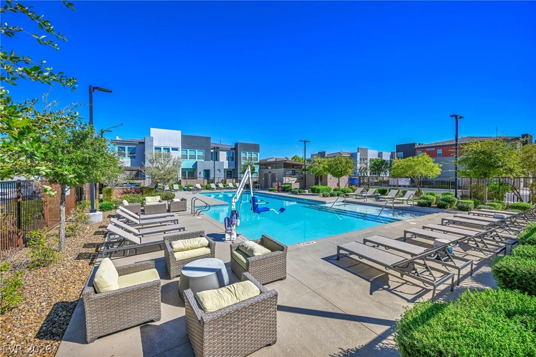 9826 Canyon Sage Street, Las Vegas, NV 89141 Sun-drenched pool area bordered by manicured hedges and modern residential architecture.
