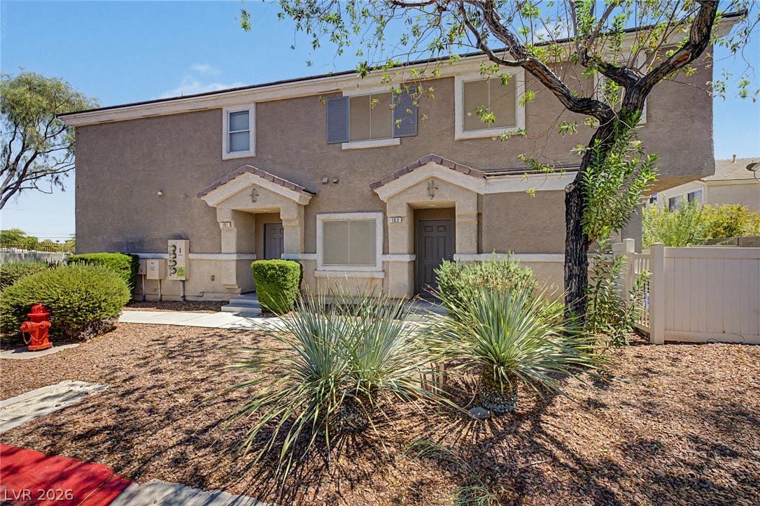 6041 Turning Spoke Trail, #102, Henderson, NV 89011 Desert landscaping and stucco siding frame the welcoming entryway of this multi-level home.