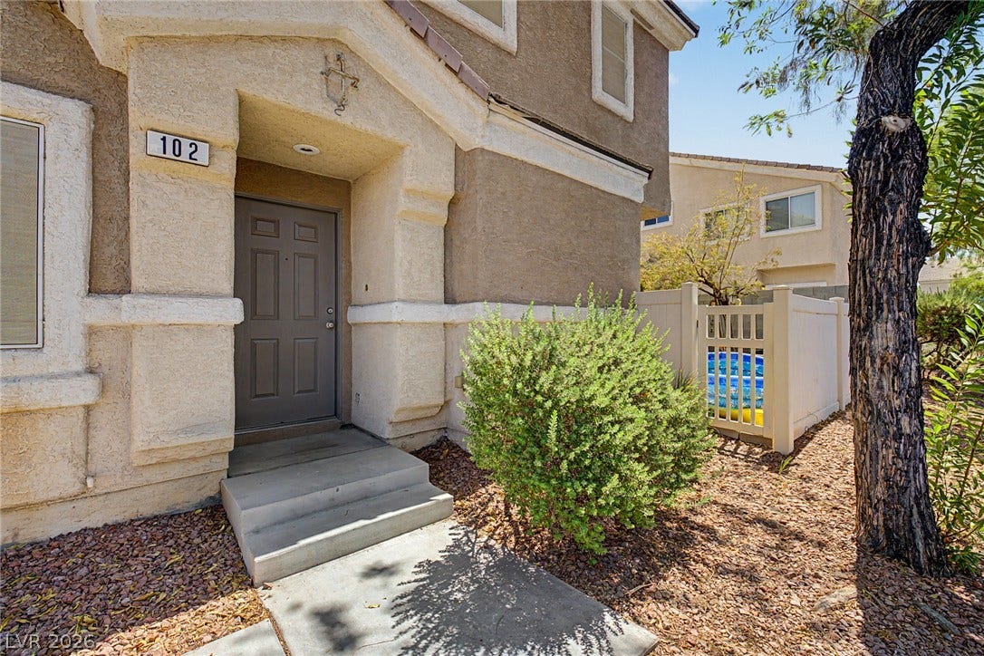 6041 Turning Spoke Trail, #102, Henderson, NV 89011 Concrete steps lead to a recessed entryway set against a classic stucco facade.
