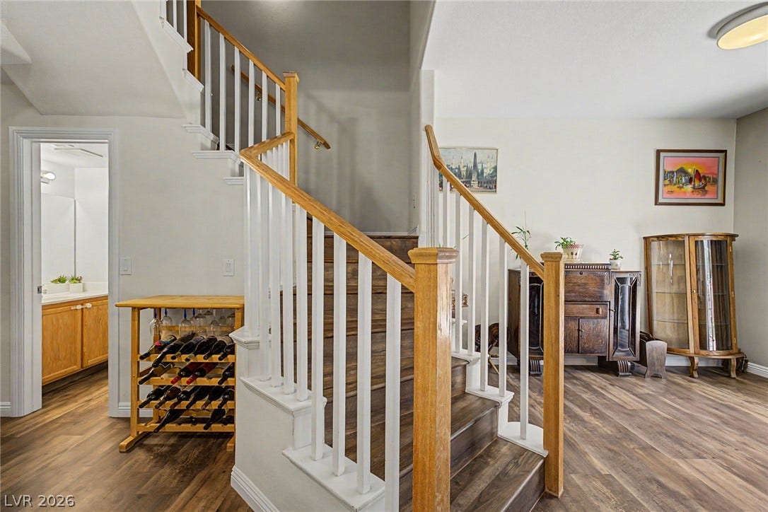 6041 Turning Spoke Trail, #102, Henderson, NV 89011 A classic wooden staircase leads upward from the open entry hall.