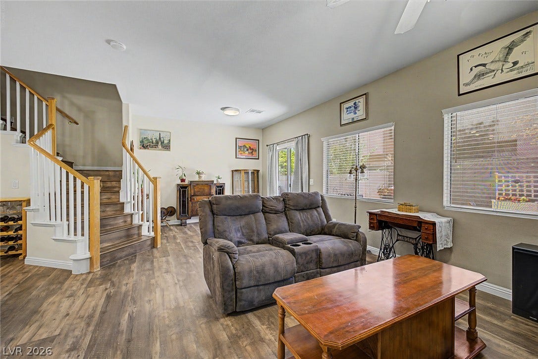 6041 Turning Spoke Trail, #102, Henderson, NV 89011 Rich wood-look flooring and an elegant wooden staircase anchor this inviting open-concept living space.