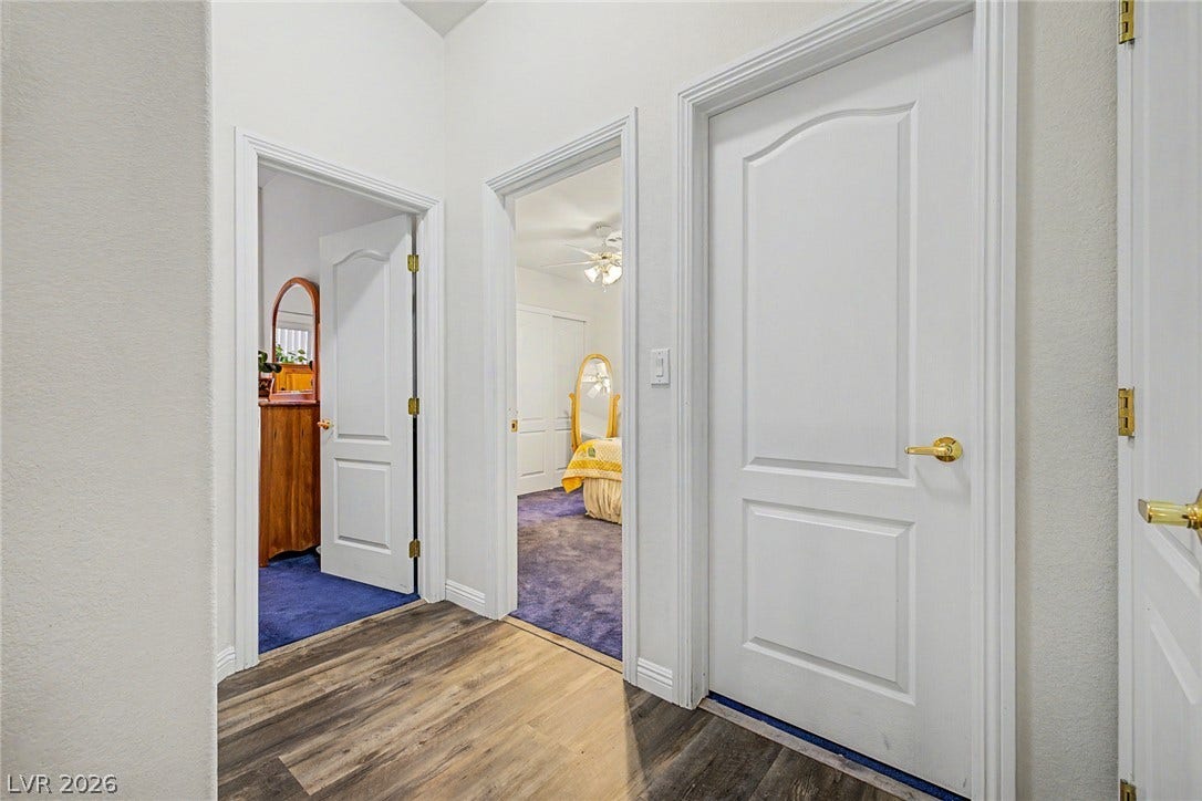 6041 Turning Spoke Trail, #102, Henderson, NV 89011 Clean lines and wood-look flooring define this hallway leading to multiple bedrooms.