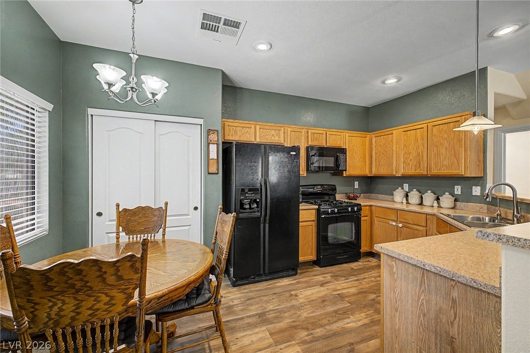 6041 Turning Spoke Trail, #102, Henderson, NV 89011 Classic wooden cabinets pair beautifully with durable laminate flooring in this functional kitchen.