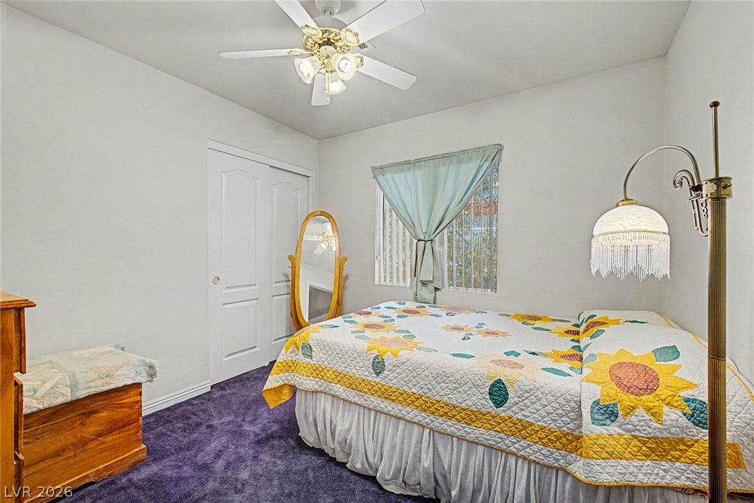 6041 Turning Spoke Trail, #102, Henderson, NV 89011 A quiet bedroom features soft carpet and standard closets alongside classic window framing.