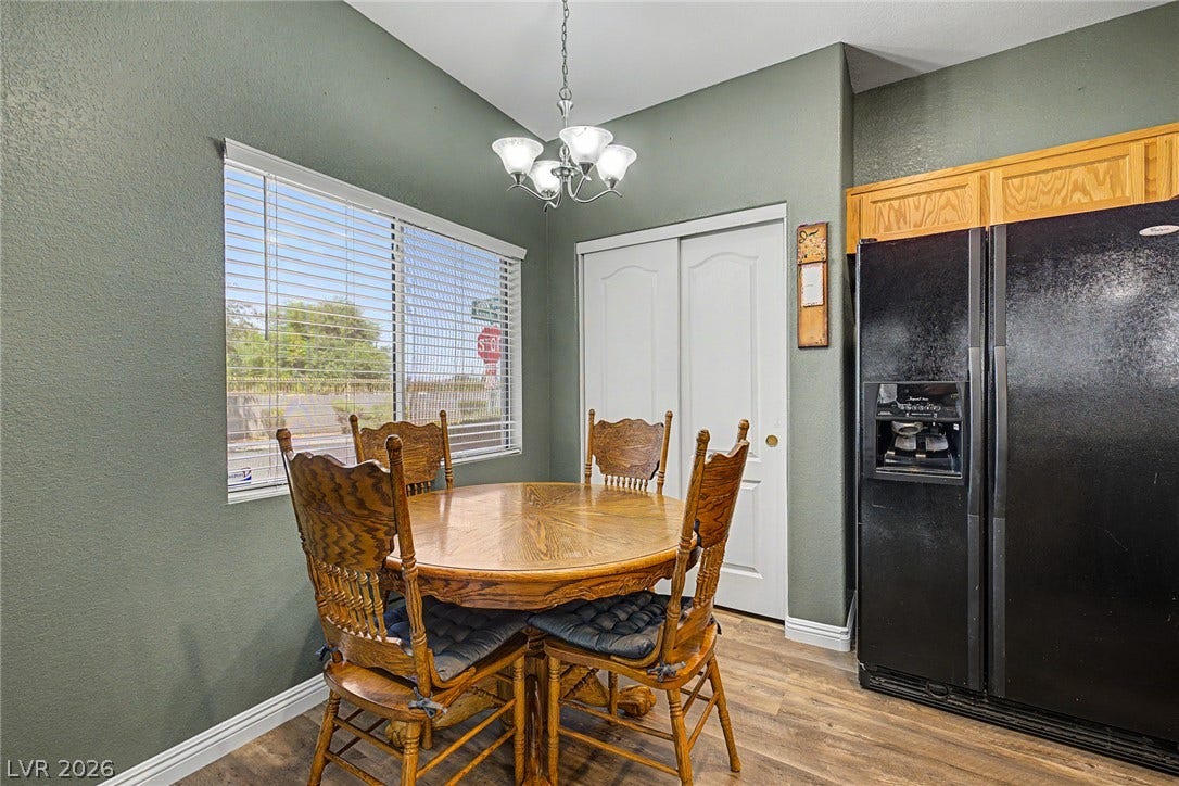 6041 Turning Spoke Trail, #102, Henderson, NV 89011 A cheerful dining area with warm wood flooring and a large window looking outside.