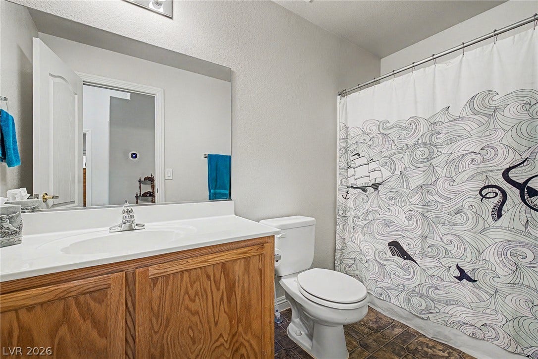 6041 Turning Spoke Trail, #102, Henderson, NV 89011 A classic wood vanity and tiled flooring anchor this functional bathroom space.