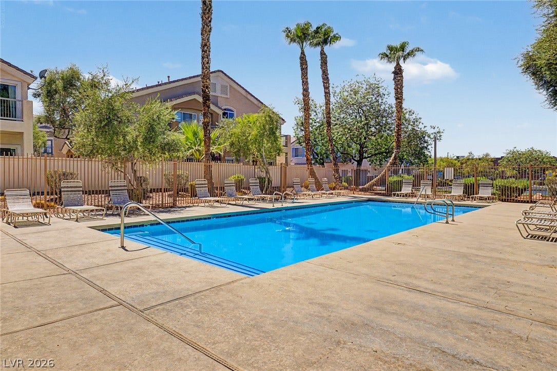 6041 Turning Spoke Trail, #102, Henderson, NV 89011 A spacious concrete deck surrounds this inviting community pool lined with palm trees.
